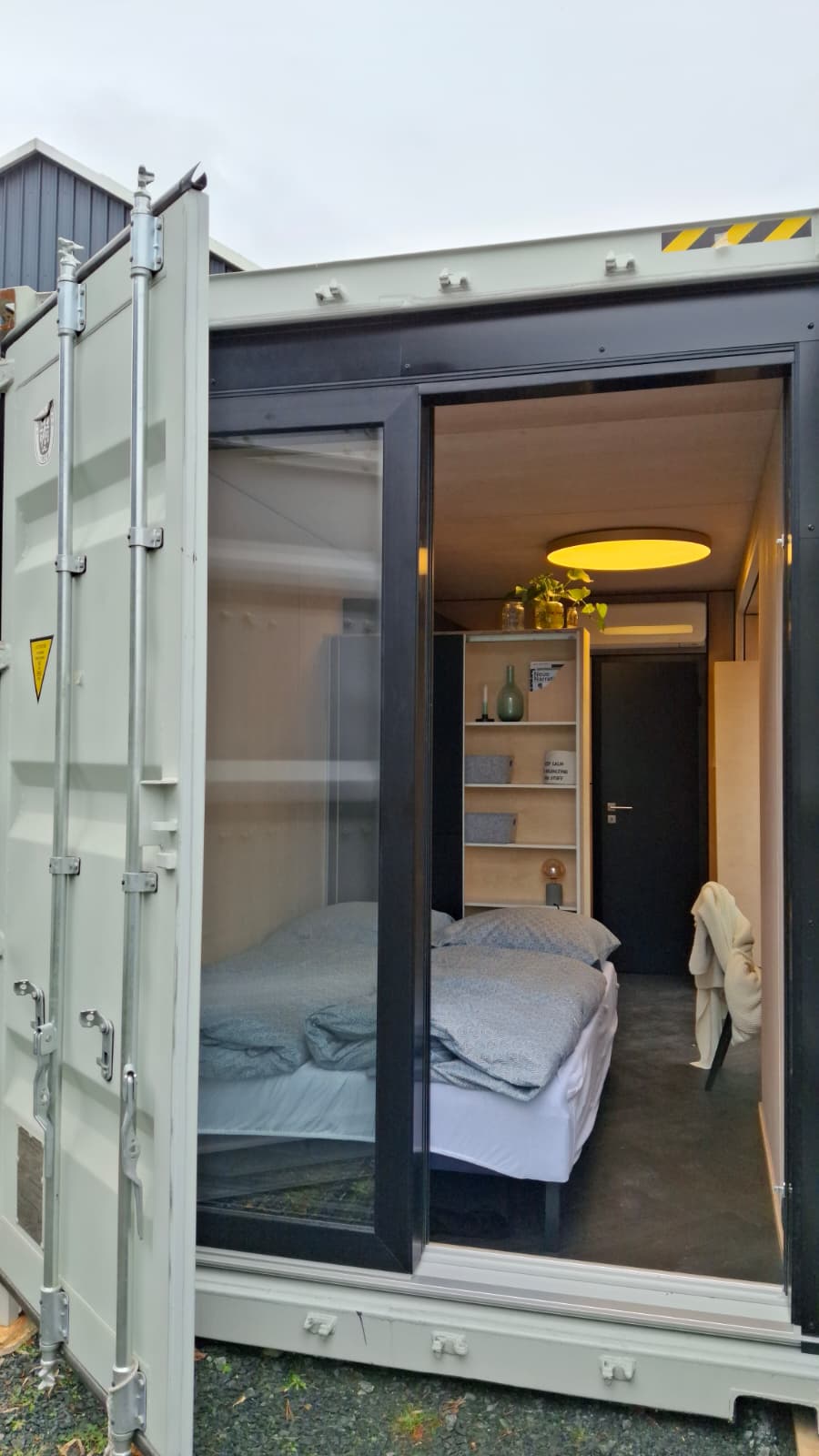 Monolith Ferienhaus mit ausgezogenem Bett und offener Tür